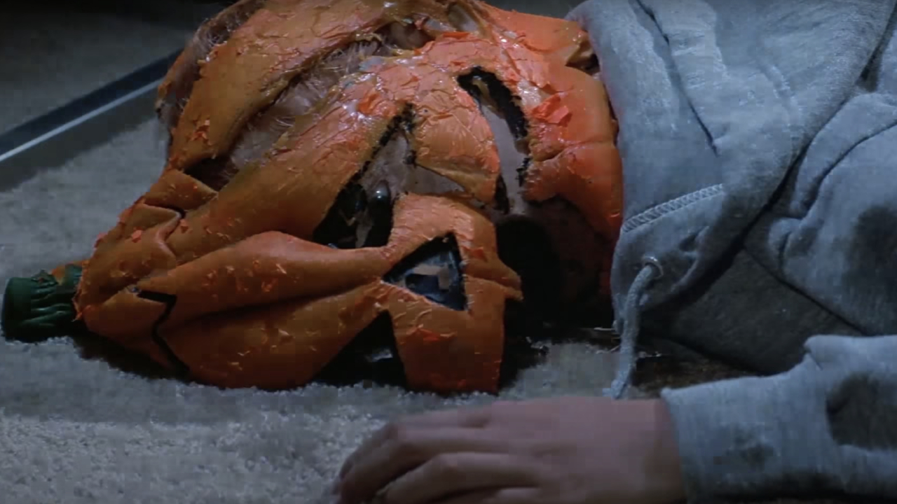 Une victime du masque jack-o-lantern Silver Shamrock dans Halloween III : Season of the Witch