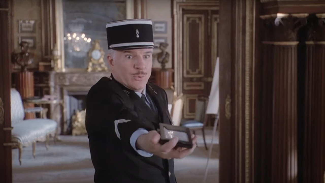 Steve Martin blickt in „Der rosarote Panther“ geschockt auf seinen Arm.