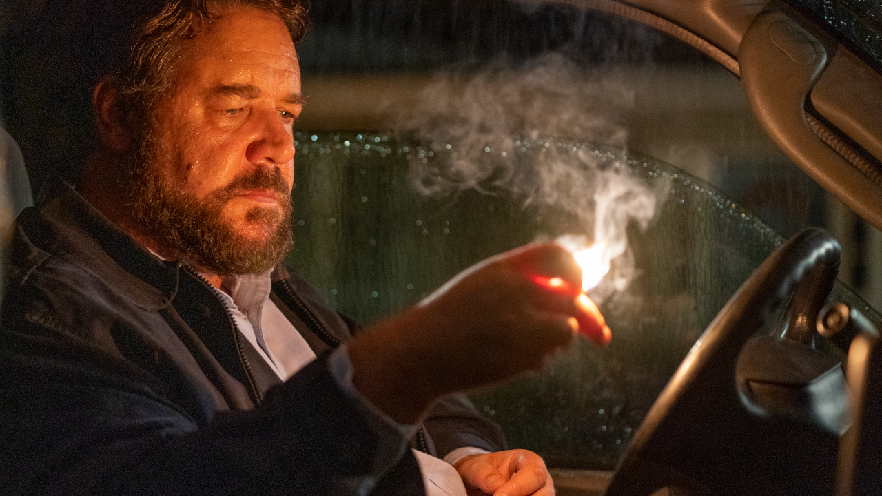 Russell Crowe starrt bedrohlich auf ein brennendes Streichholz in „Unhinged“.