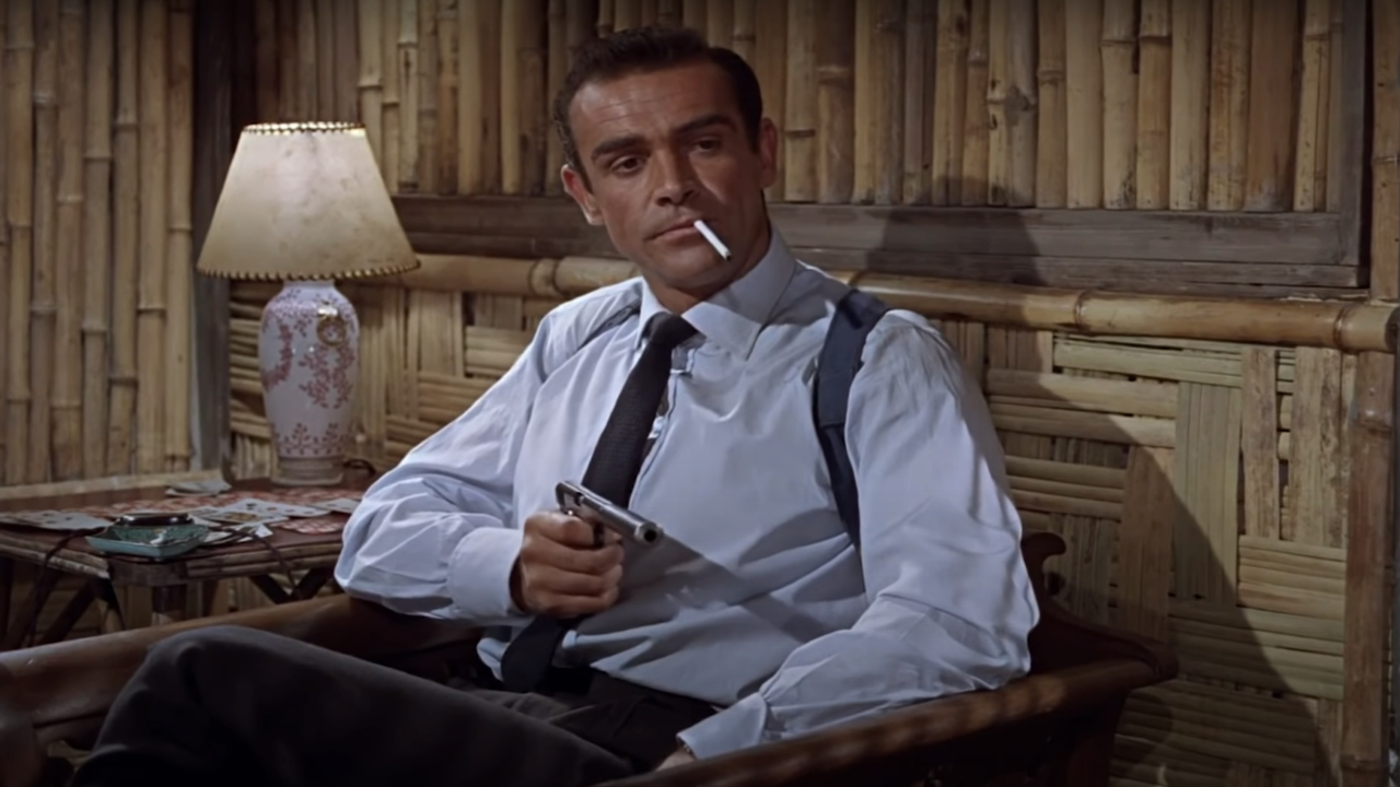 Sean Connery pointe calmement son arme dans sa chambre d'hôtel dans Dr. No.