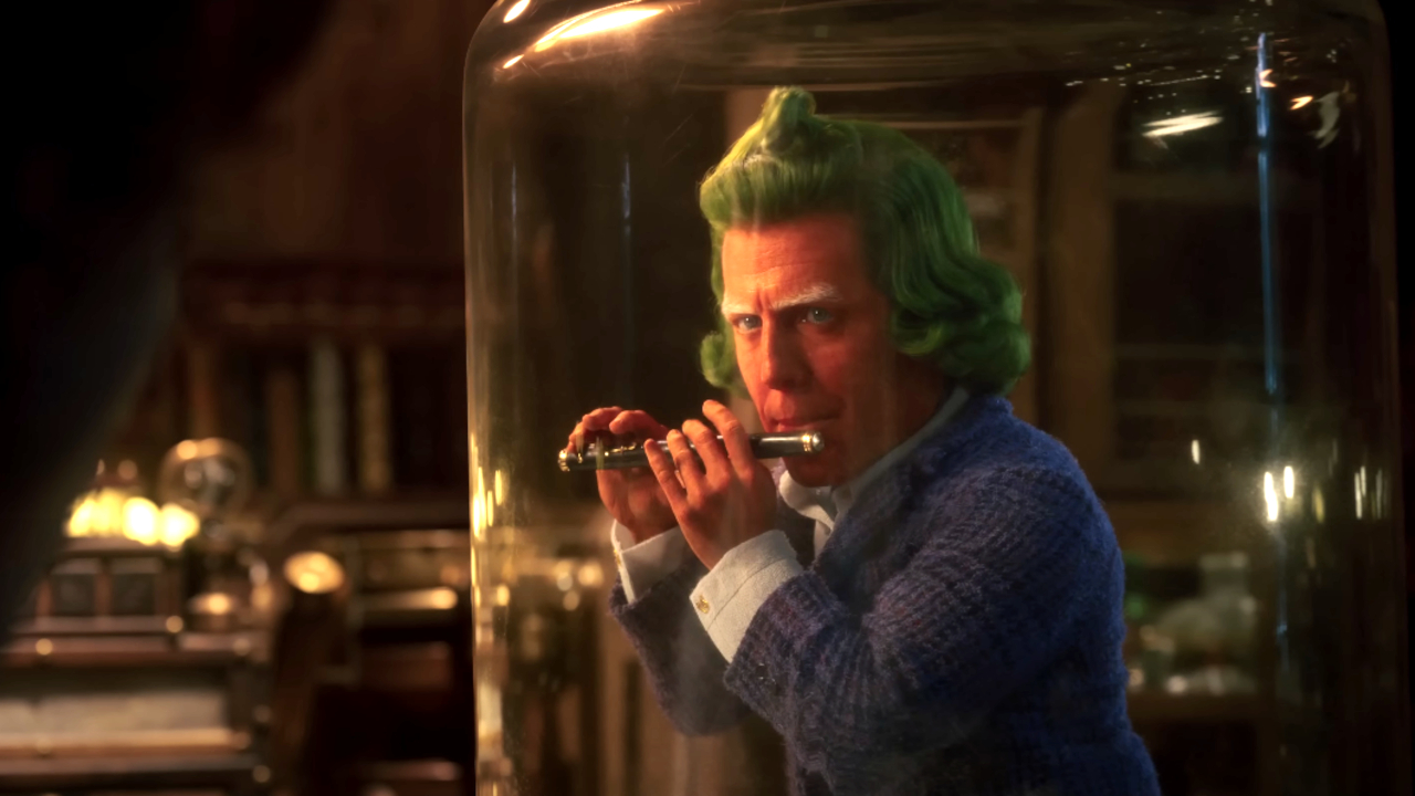 Oompa Loompa de Hugh Grant joue de la flûte, alors qu'il est retenu captif sous verre, à Wonka.