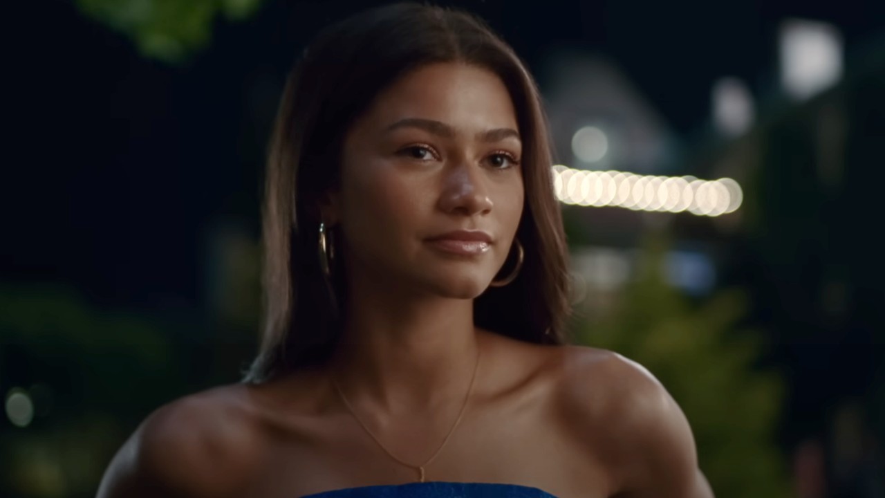 Zendaya freut sich, während sie in Challengers ein trägerloses blaues Kleid trägt.